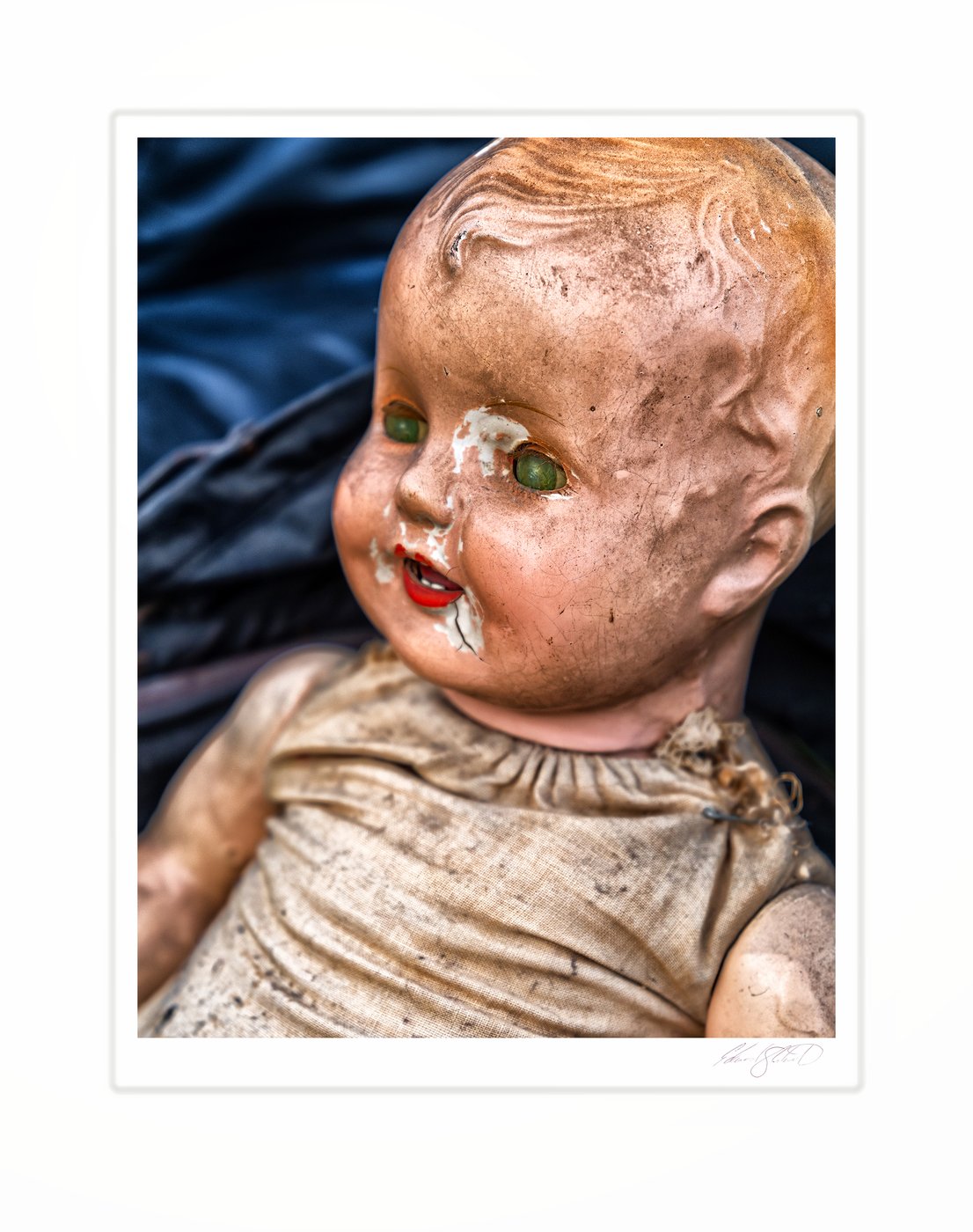 A weathered antique doll with cracked, peeling paint and haunting green eyes. West Hollywood, California -2022
