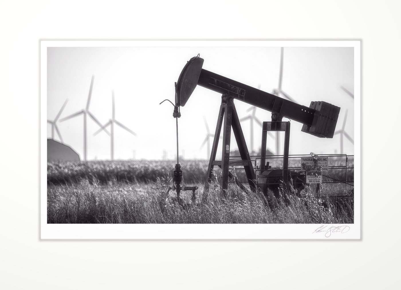 An oil pumpjack with wind turbines behind. Wisner, Michigan -October 2018