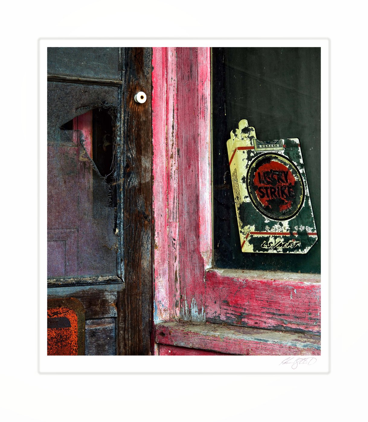 A weathered screen door and peeling Lucky Strike sign at an old gas station. Kilmanaugh, Michigan -2014