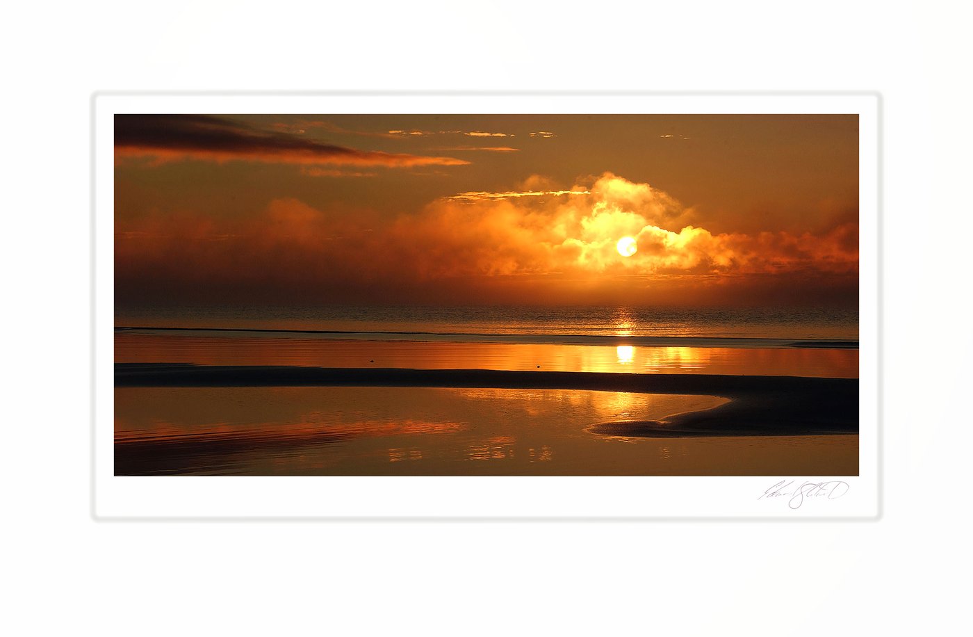 The sun rising through clouds over Lake Michigan and its sandbars. Naubinway, Michigan -August, 2004