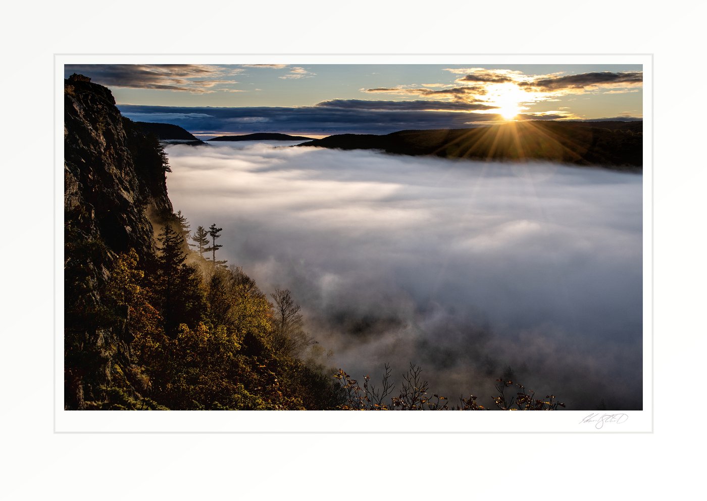 Sunrise breaking over a fog-filled valley at Lake of the Clouds in the Porcupine Mountains. Ontonagon, Michigan -October 2023