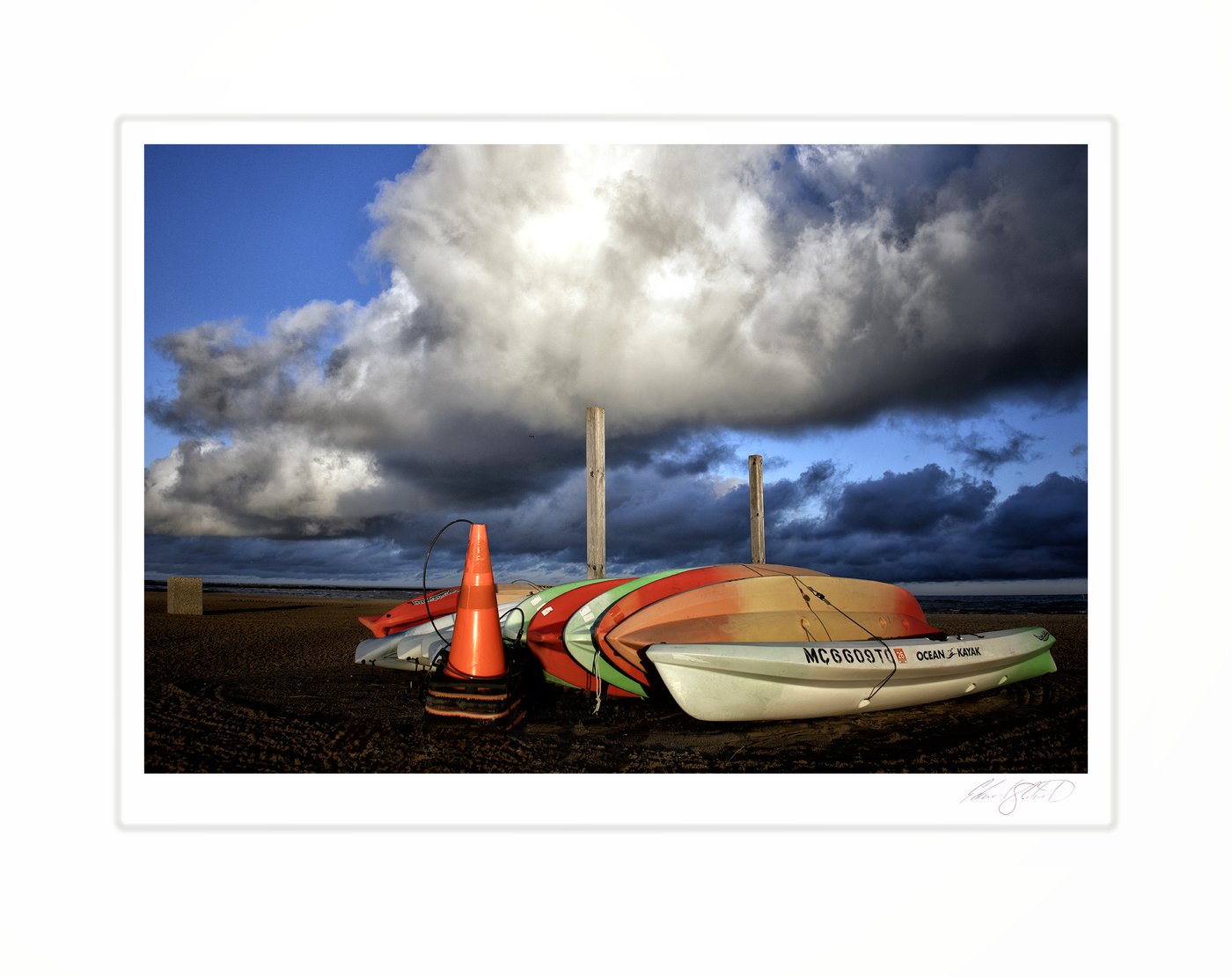 A row of kayaks on Caseville beach beneath a towering storm cloud. Caseville, Michigan -August, 2023