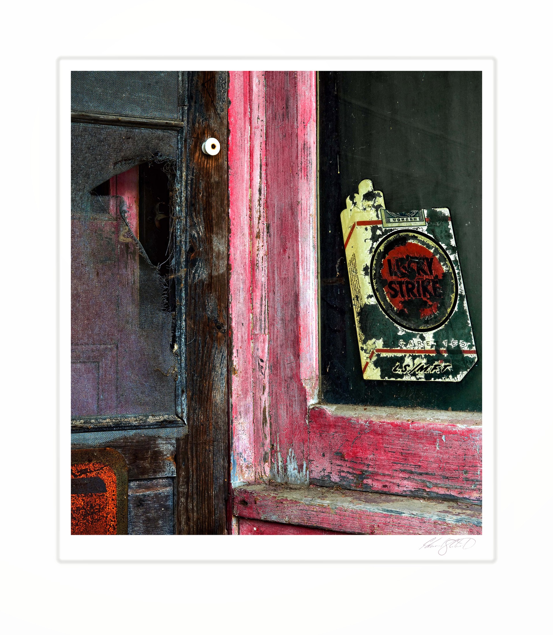 A weathered screen door and peeling Lucky Strike sign at an old gas station. Kilmanaugh, Michigan -2014